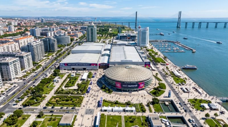 Aerial view of the Altice Arena and FIL exhibition centre in Parque das Nações, Lisbon, the venue for Web Summit 2026, surrounded by the Tagus River waterfront